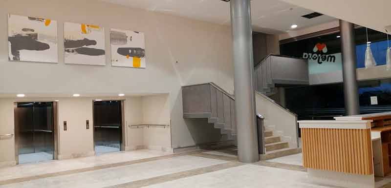 Interior de dos pisos con acceso a ascensores y escalera