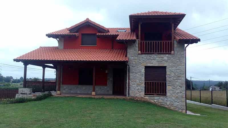 Vistal frontal de chalet rojo en Siero