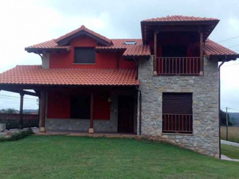 Vistal frontal de chalet rojo en Siero